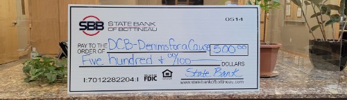 Photo of check donation to Denims.