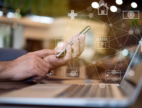 Man holding phone with computer and banking symbols.