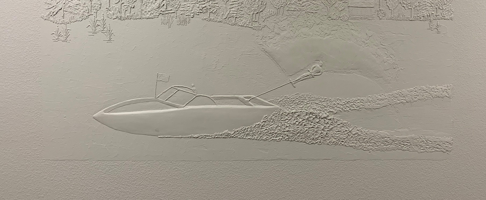 Wall art of boat on lake pulling skier.