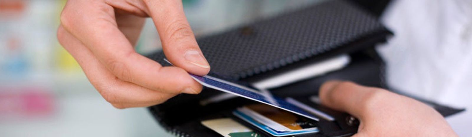 Person putting debit card into wallet.